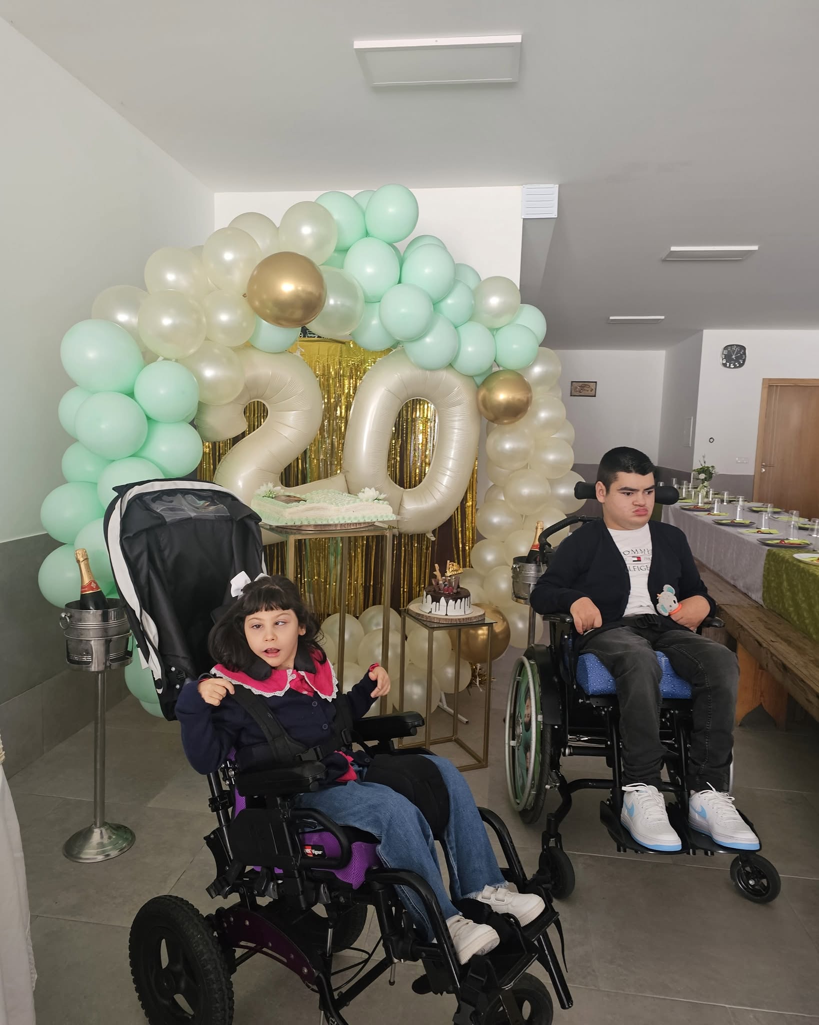 Duas crianças da ASLA num convívio festivo com balões e decoração especial, partilhando um momento de alegria
